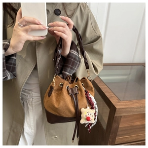 Brown frosted leather bucket bag with twisted handle and drawstring closure detail