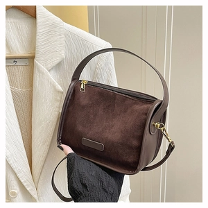 Détail de la texture en daim mat et couture en cuir lisse sur un grand sac fourre-tout