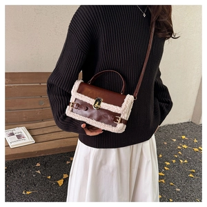 Detail of vintage crossbody bag with brown leather and white shearling trim in autumn setting