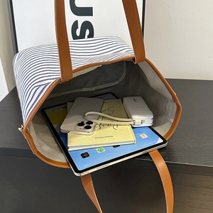 Large blue and white striped canvas tote bag with brown leather straps and interior view