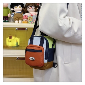 Detail showing colorful patchwork crossbody bag with pockets and adjustable straps