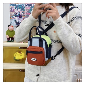 Close-up of color-block waterproof nylon mini bag with adjustable strap and front pocket