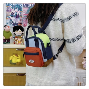 Detail of multi-color nylon mini backpack showing orange and blue contrast waterproof fabric