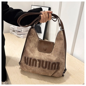 Detail of vintage brown canvas tote bag with leather straps and textured stitching
