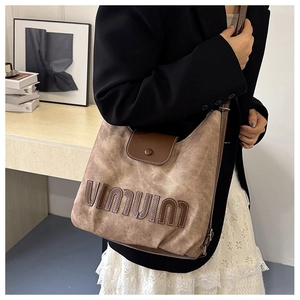 Detail der Vintage-Canvas-Tasche mit Kontrast-Lederbesatz und Logo-Stickerei