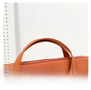 Détail de la couture de la poignée et de la fermeture éclair du porte-documents orange