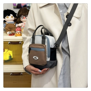 Detail view of mini crossbody bag with multi-layer pockets and contrast color design