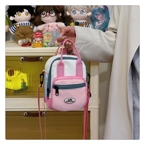 Close-up of a mini pink and green multi-functional canvas bag with a front zip pocket