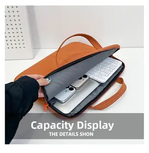 Sacoche orange montrant le rangement pour ordinateur, clavier et deux smartphones