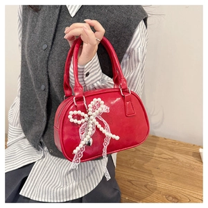 Detail of red bowling bag featuring pearl bow and white lace ribbon decoration