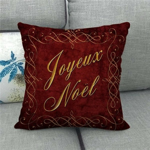 Nahaufnahme dunkelroter Kissenbezug mit goldenem Joyeux Noel Schriftzug und Ornamentrand