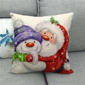 Detailed view of linen Christmas pillowcase featuring Santa and snowman on gray sofa