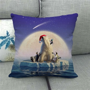 Christmas cushion cover with polar bear and penguin on a sofa in a home setting