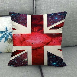 Detail of a Union Jack linen cushion with cosmic nebula patterns on a grey fabric sofa