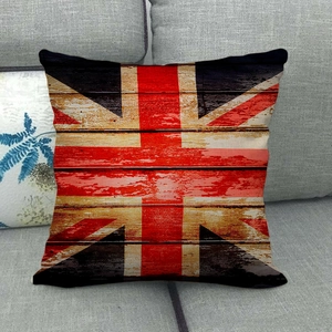 Detail of vintage Union Jack linen cushion cover on grey sofa with wood stripe texture
