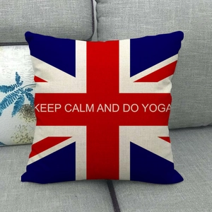 Detail of Union Jack linen pillow cover with Keep Calm and Do Yoga text on grey sofa