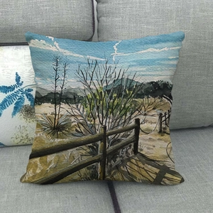 Detail of linen cushion cover with watercolor landscape art on a grey sofa