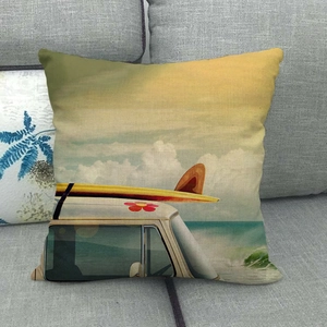 Linen cushion cover with vintage summer beach van print shown on a gray sofa setup