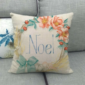 Gros plan sur la housse de coussin de Noël en lin avec couronne et lettrage Noel bleu