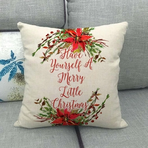 Détail d'une housse de coussin de Noël avec couronne et lettrage festif sur lin