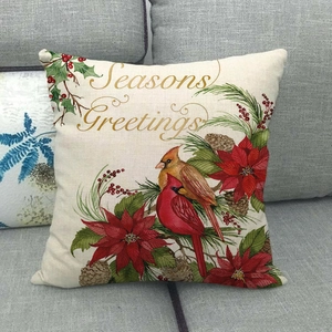 Détail d'une housse de coussin de Noël en lin avec texte Seasons Greetings et oiseaux rouges