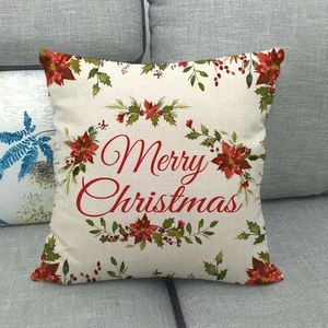 Détail d'une taie d'oreiller en lin avec couronne de Noël et texte festif de couleur rouge