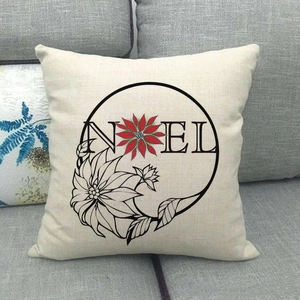 Gros plan de taie d'oreiller en lin avec motif floral Noel sur canapé gris