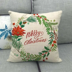 Housse de coussin en lin Merry Christmas avec couronne de fleurs sur un canapé gris
