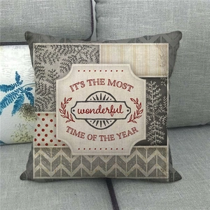 Detail of Christmas linen pillowcase with seasonal typography on gray sofa