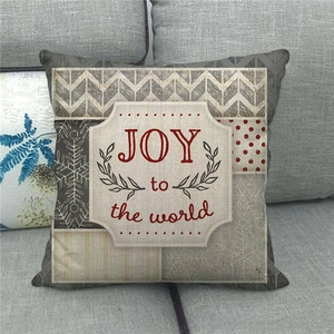 Close-up of linen Christmas pillow case with JOY to the world print on a sofa