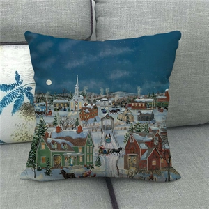Close-up of linen pillowcase with winter snow town scene on a grey fabric sofa