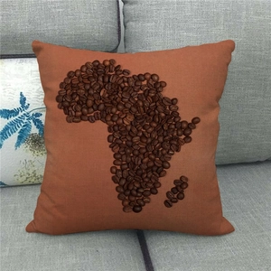 Detail van linnen kussen met Afrika-kaart van koffiebonen op een grijze stoffen bank