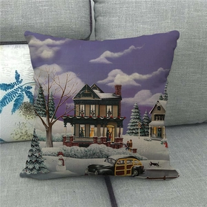 Linen Christmas pillow case with winter snow scene painting on a cozy grey sofa
