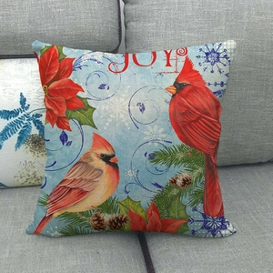 Detail of Christmas pillow cover with red cardinals, poinsettia flowers and JOY lettering