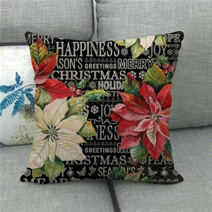 Close-up of a festive linen Christmas pillow cover with red poinsettia and holiday text