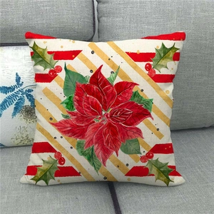 Close-up of linen Christmas pillow case with red poinsettia and golden stripe patterns