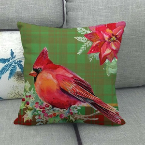Christmas pillow cover with red cardinal and floral design on a gray sofa background