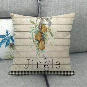 Close-up of linen Christmas pillow case with bell design and Jingle text on a sofa