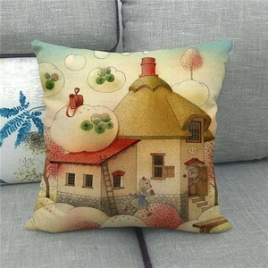 Detail of linen pillowcase featuring a cozy cottage illustration on a grey sofa