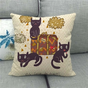 Detail of linen cushion cover with cartoon cat and travel text on a gray sofa