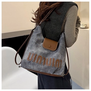 Detail der großen Vintage-Canvas-Tasche mit Kontrast-Lederbesatz und gesticktem Logo-Schriftzug