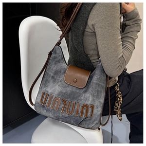 Detail of grey canvas tote backpack with brown leather flap and leopard print scarf accent