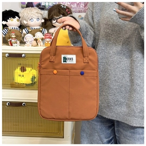 Sacoche pc en toile marron avec deux poches frontales et boutons orange contrastés