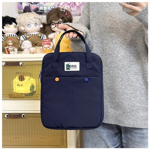 Détail d'une sacoche bleue pour ordinateur avec deux poches et boutons colorés