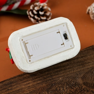 Detail view of the battery compartment and power switch on the Christmas resin ornament
