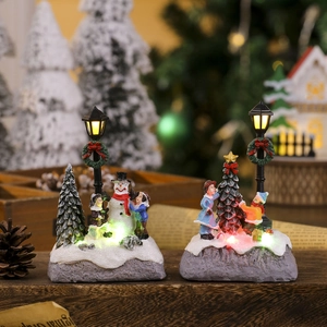 Close-up of lighted Christmas resin miniature with snowman and LED street lamp detail