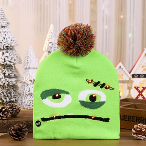 Detail view of green monster LED knit hat with glowing eyes and colorful pompom