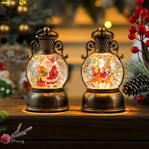 Detail of vintage bronze Christmas lanterns featuring Santa scenes and swirling snow effects