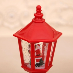 Close-up of a red Christmas water lantern featuring Santa Claus and swirling glitter