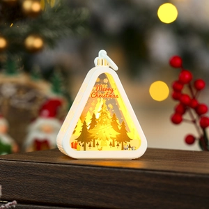 Close-up of LED Christmas lantern with warm glow and Merry Christmas gold tree design